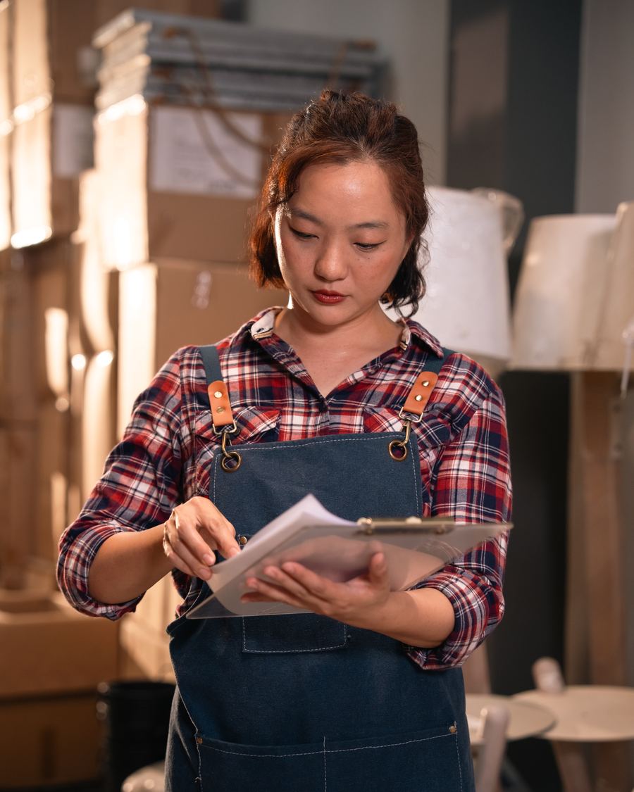 Trade customer reviewing account application paperwork on a clipboard in a storeroom